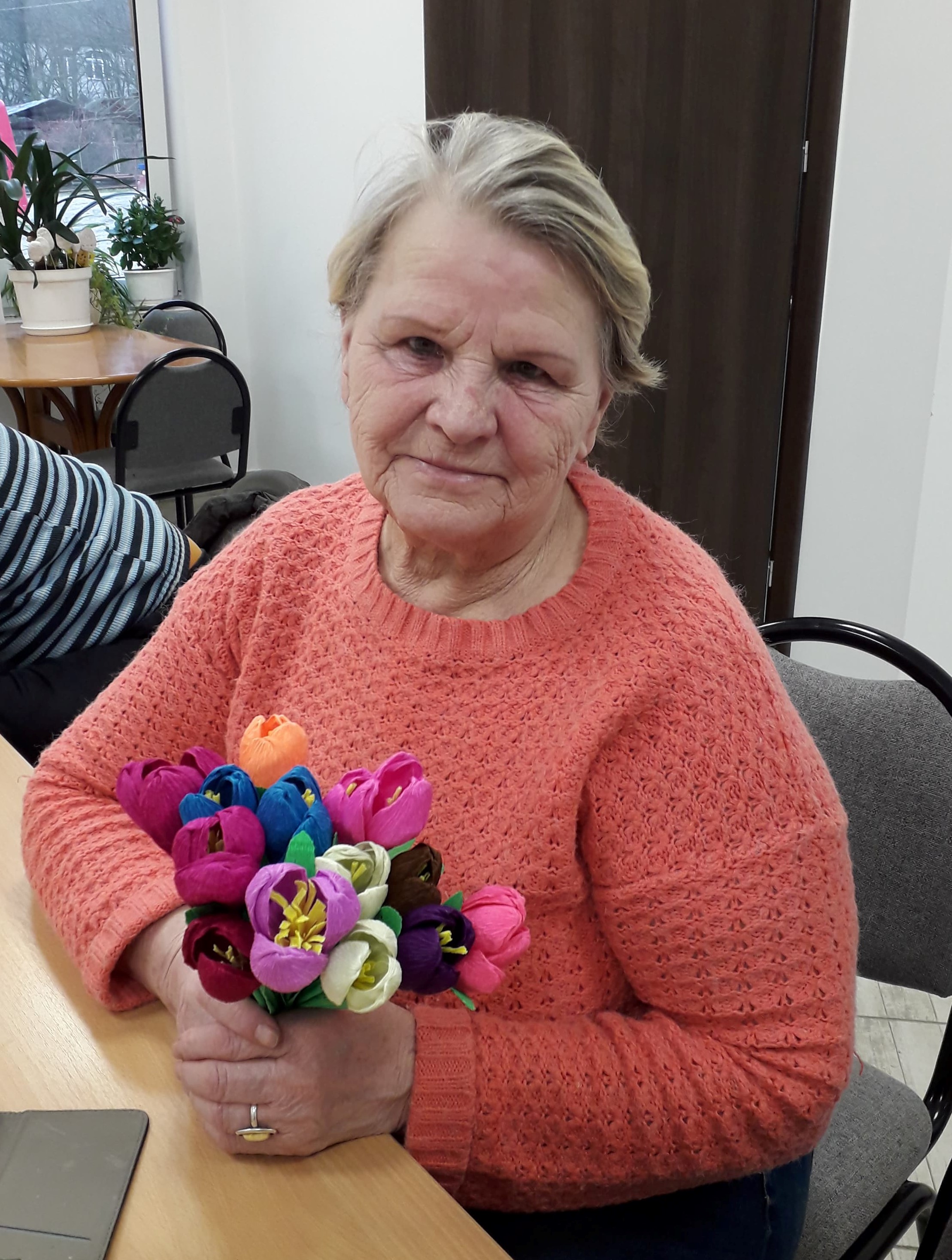 Seniorka z otrzymanymi od wolontariuszy kwiatami.