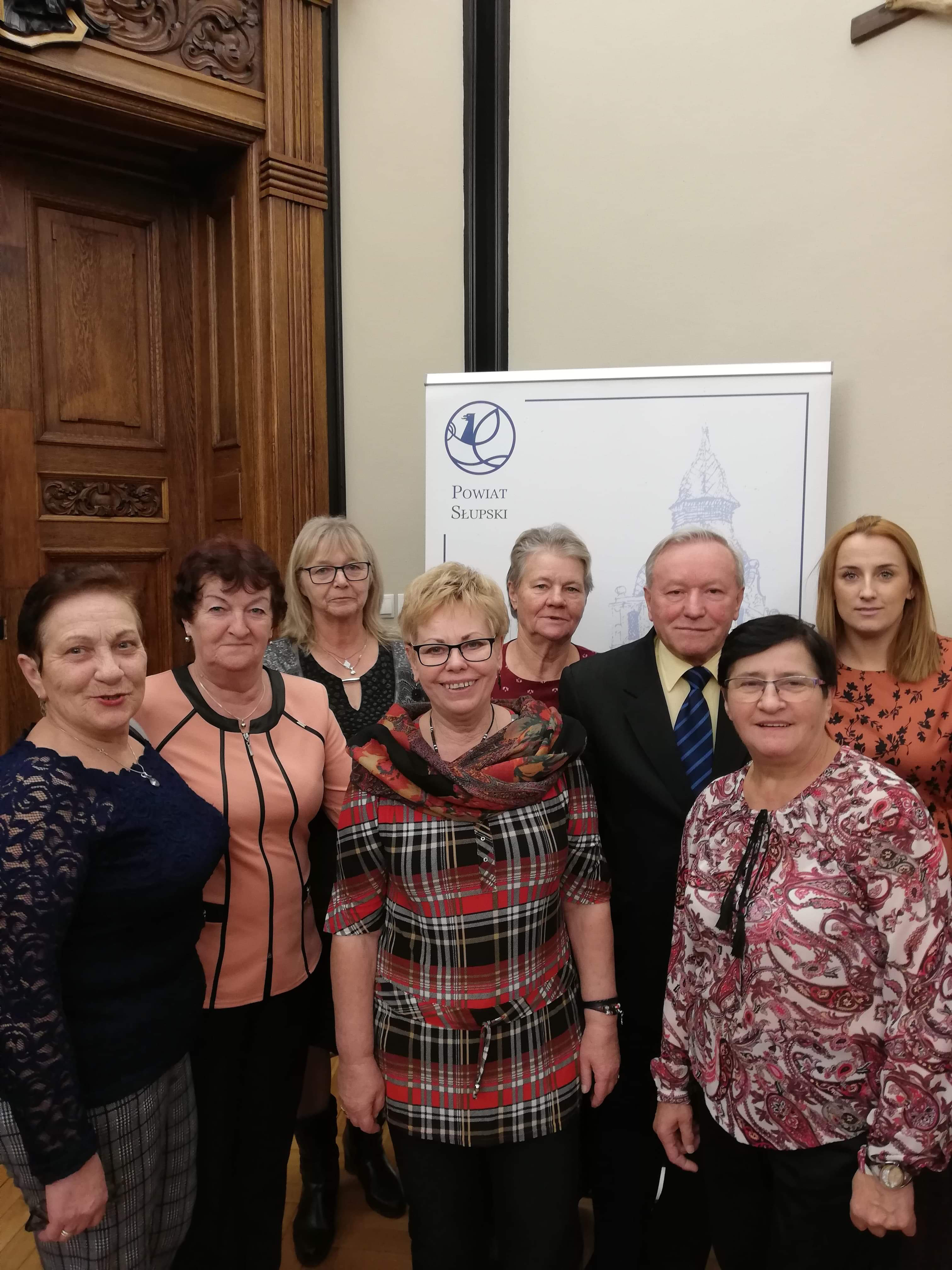 Grupa reprezentantów z gminy Główczyce pozująca do zdjęcia przed wejściem do sali.