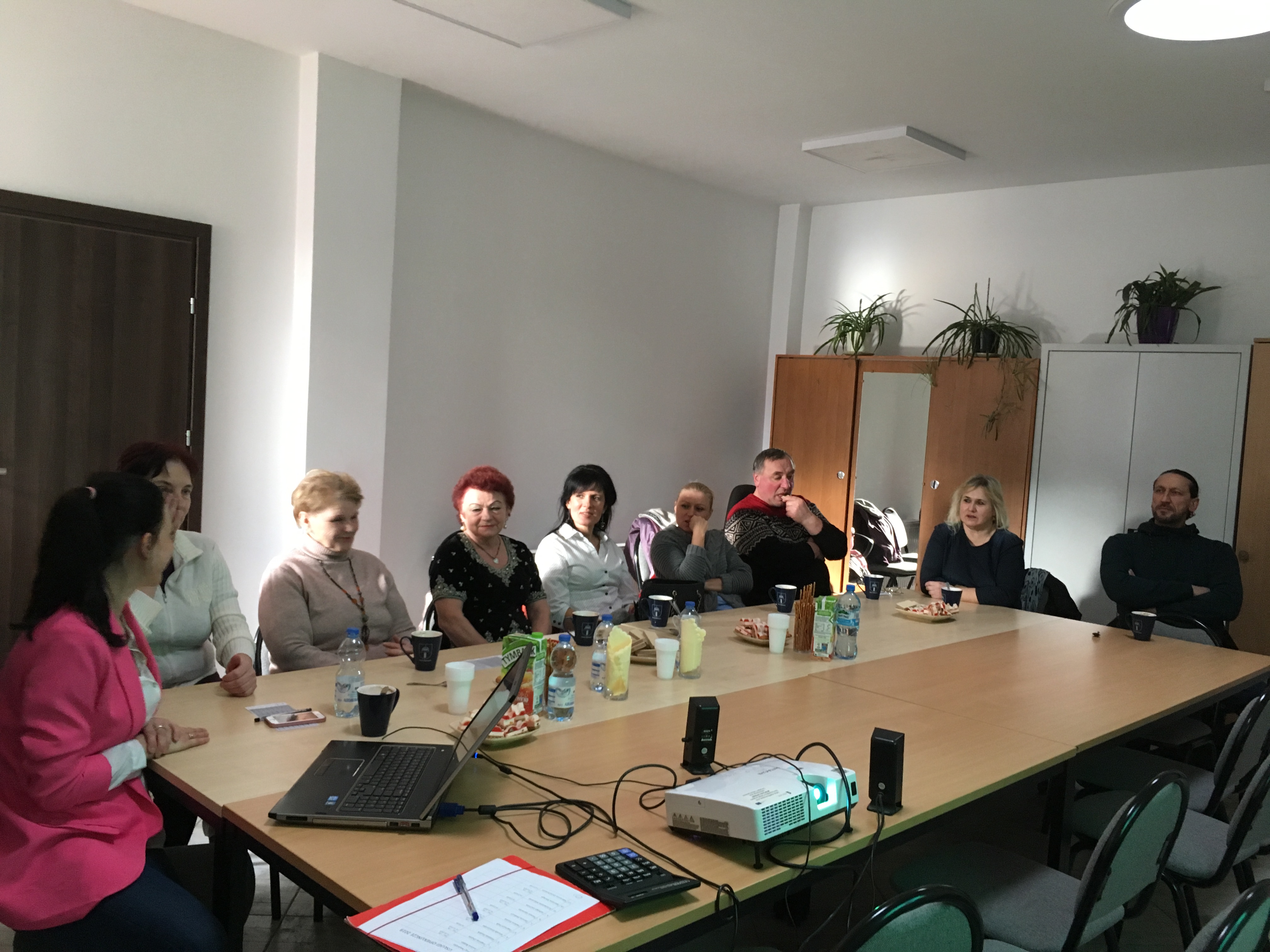 Grupa opiekunów osób starszych oraz trener podczas szkolenia.