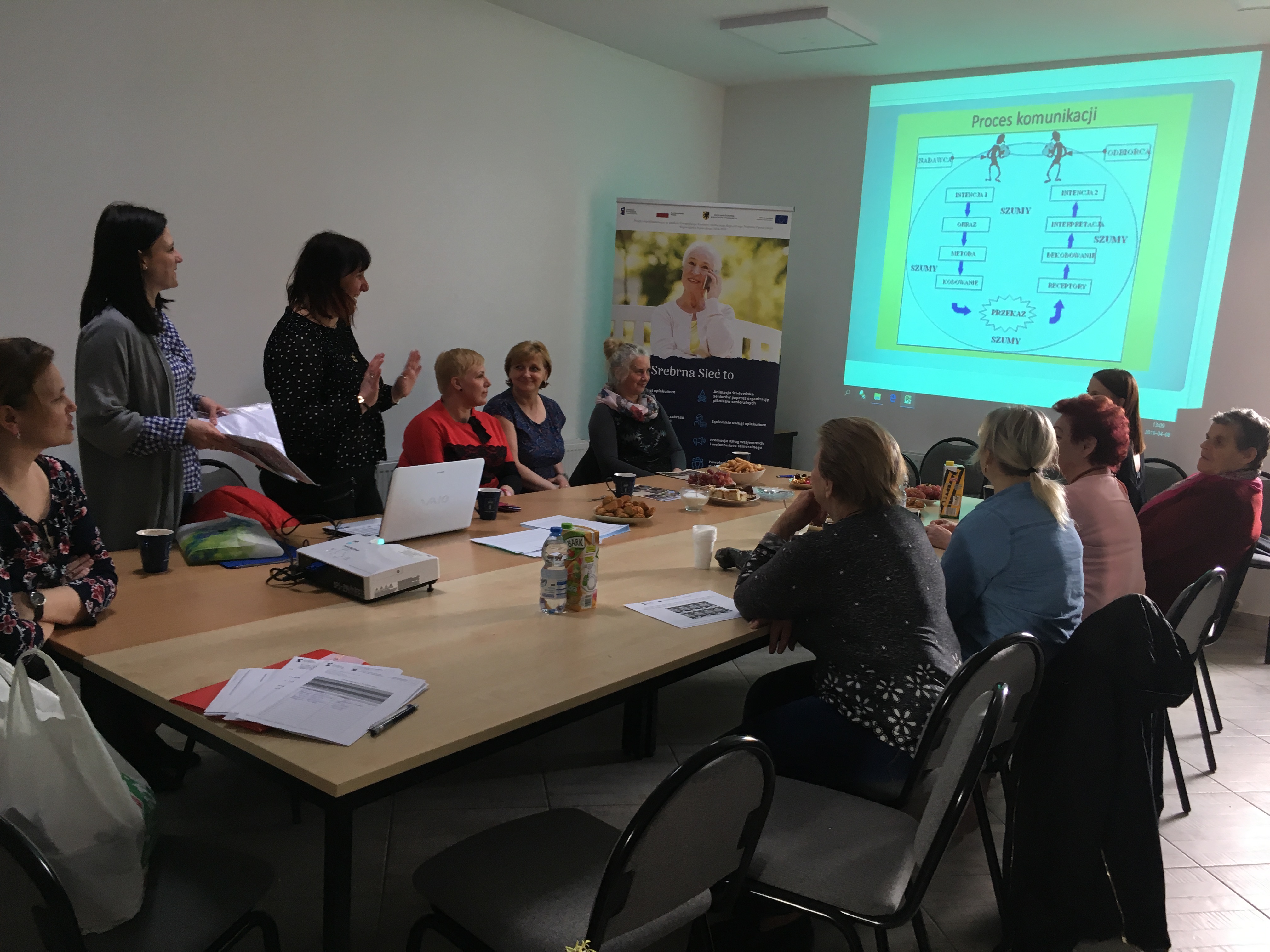 Opiekunowie faktyczni podczas szkolenia przeprowadzanego w Główczycach, na tle wyświetlanej prezentacji multimedialnej dotyczącej komunikacji.