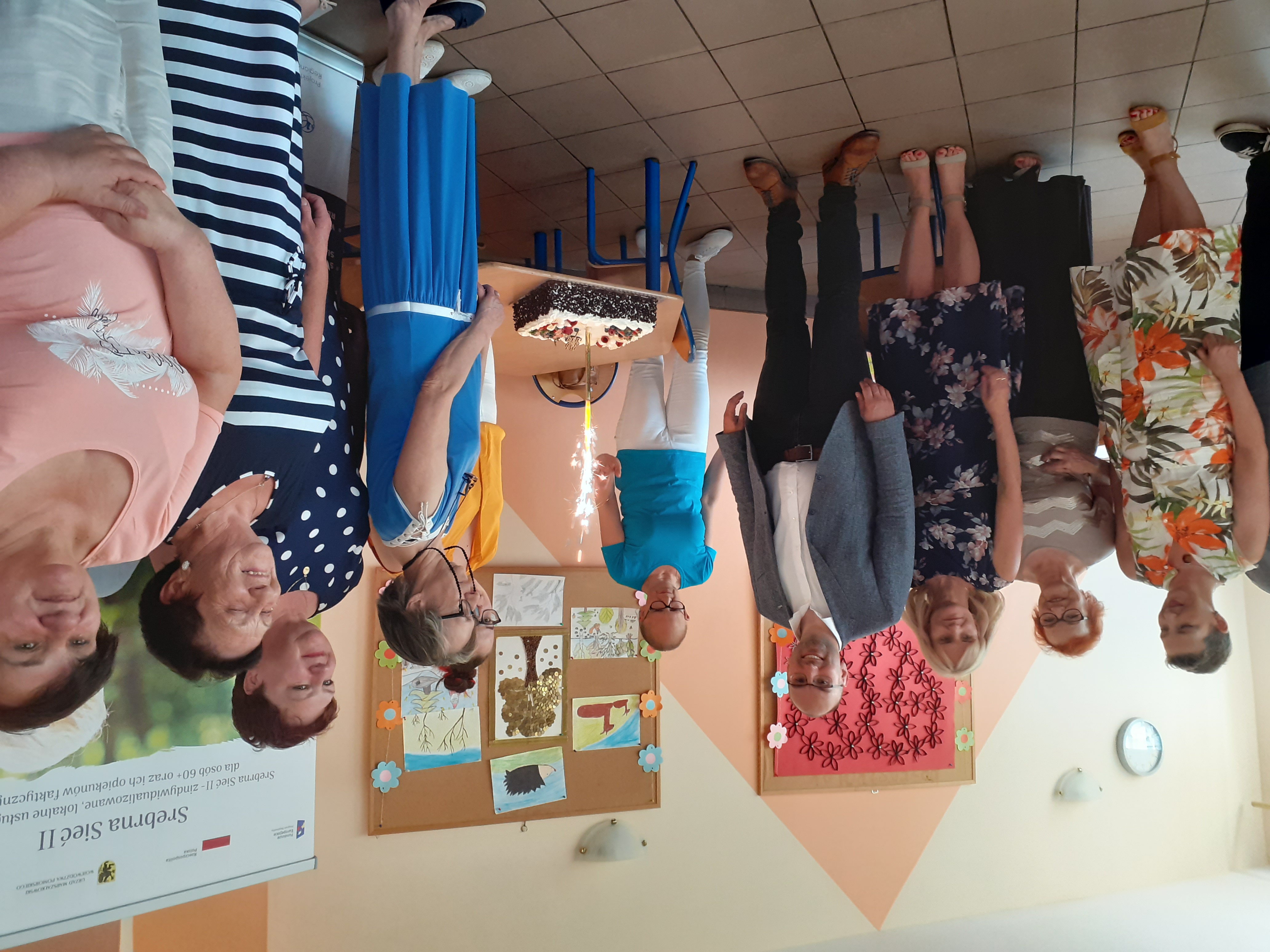 Zebrani goście na otwarciu Klubu Seniora przy torcie.