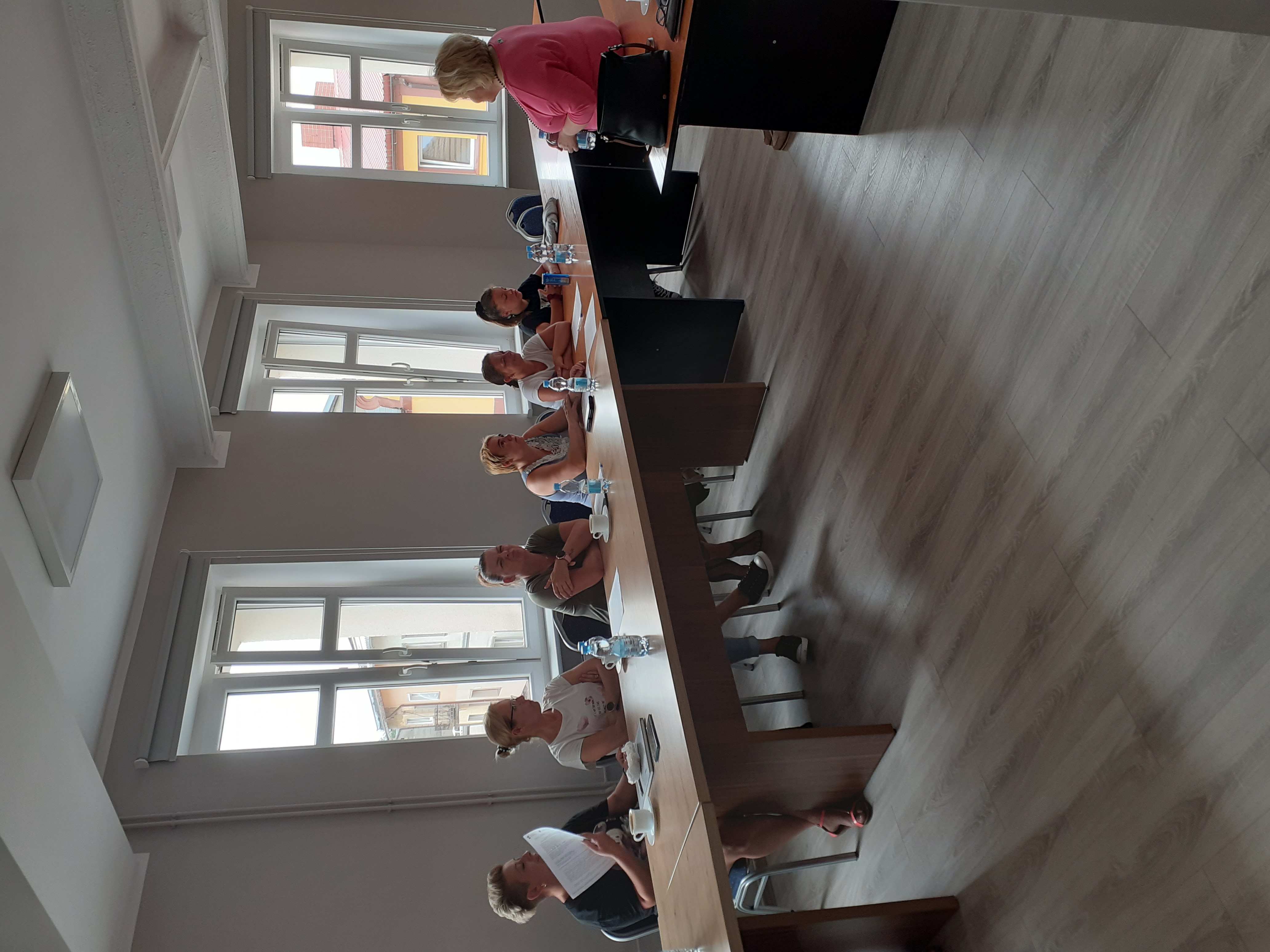 Uczestnicy szkolenia siedzący przy stołach z materiałami.